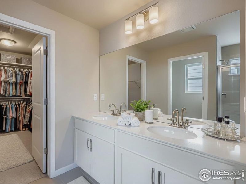 Primary en suite with double, undermount sinks and white soft-close cabinetry.