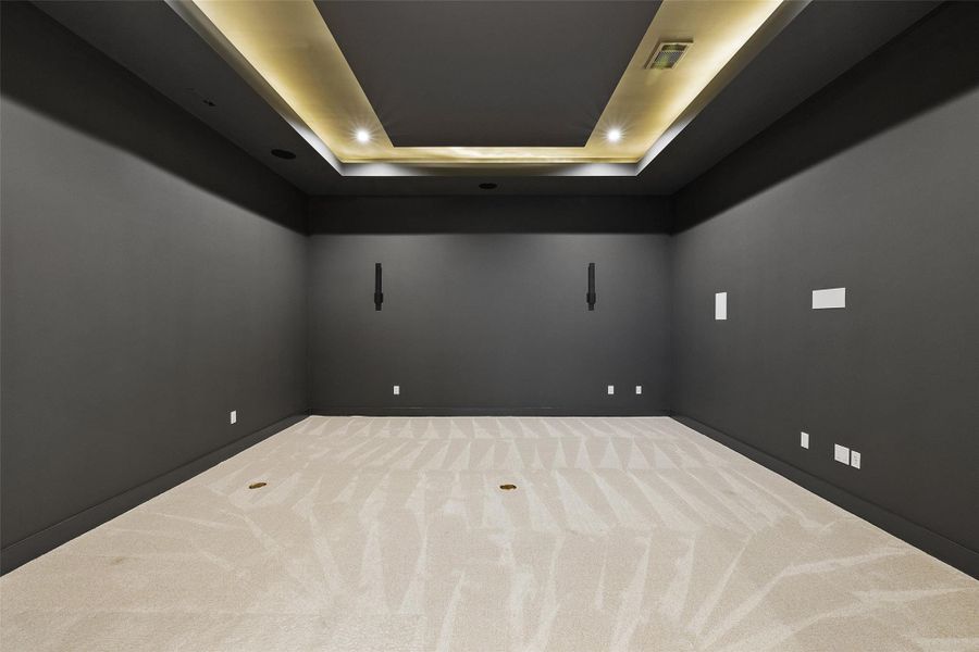 Carpeted empty room featuring a raised ceiling and recessed lighting