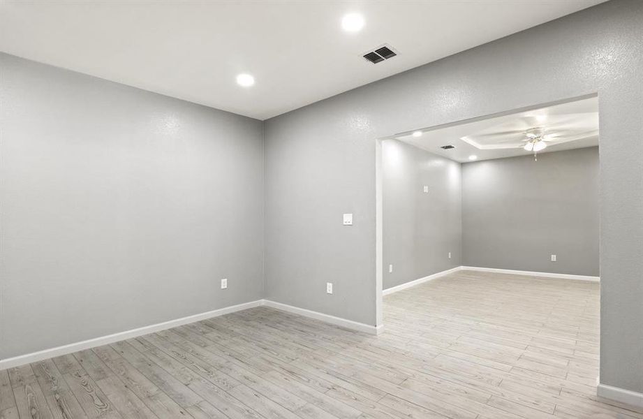 Spare room featuring light wood finished floors, a ceiling fan, and recessed lighting