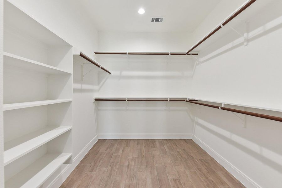 Spacious Primary closet with visible vents and light wood finished floors