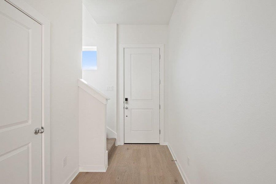 Hall with baseboards and light wood-style flooring