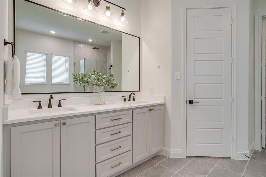 Primary Bathroom with vanity, walk in shower with standard shower head and rain head, freestanding tub, and large walk in shower