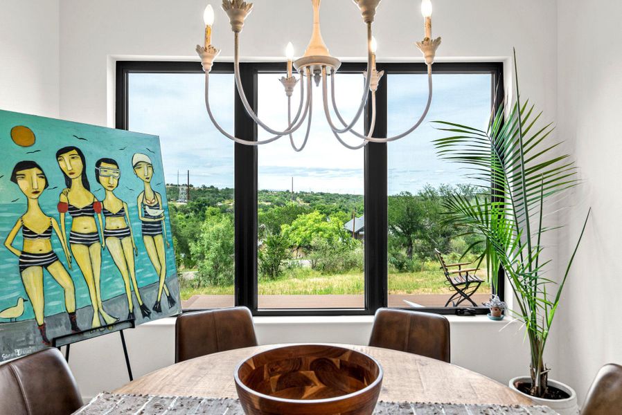Large picture windows frame serene, leafy views from this inviting dining space.