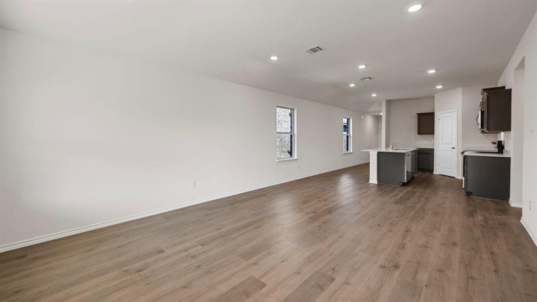 Unfurnished living room featuring recessed lighting and dark wood finished floors