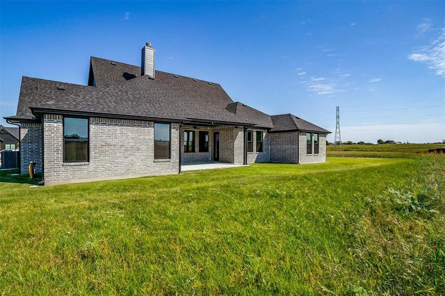 Back of house featuring a patio area and a lawn