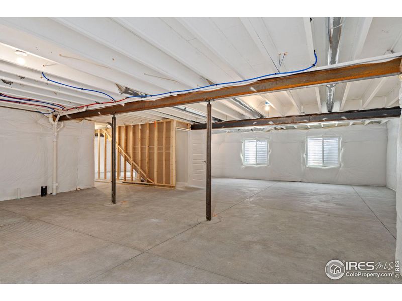 Unfinished basement ready for buyer's expansion; beams have fire-proof coating