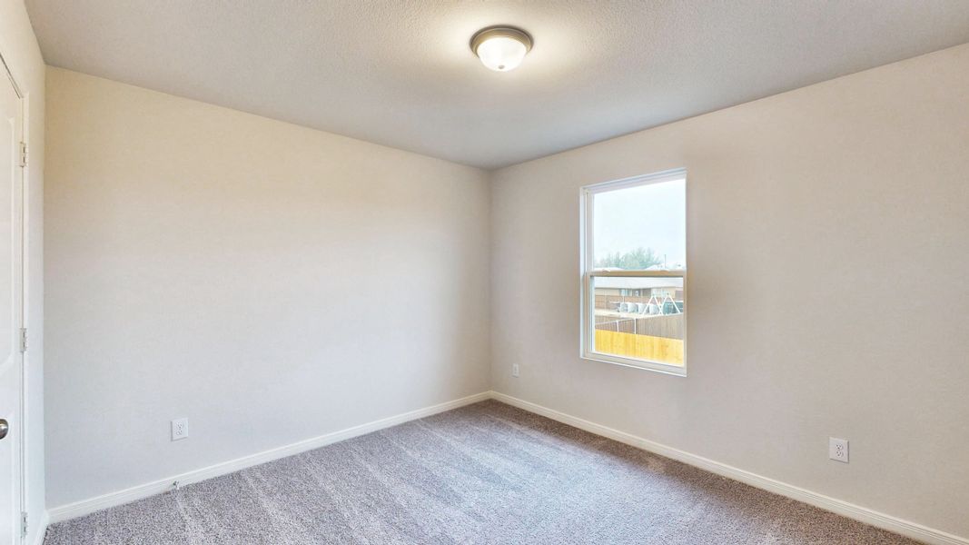 A room with a window and a carpet.