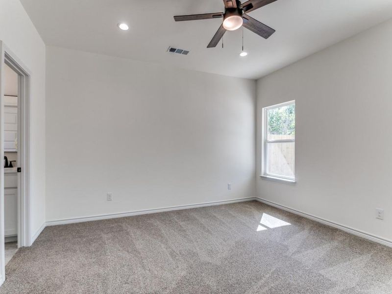 Empty room featuring light carpet and ceiling fan