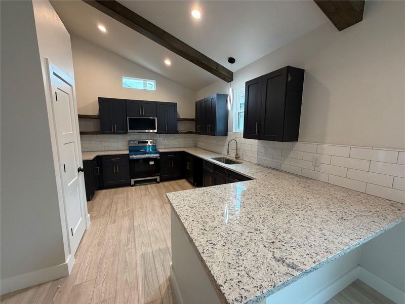Modern kitchen with granite counters and rich dark cabinetry provides an inviting culinary space.