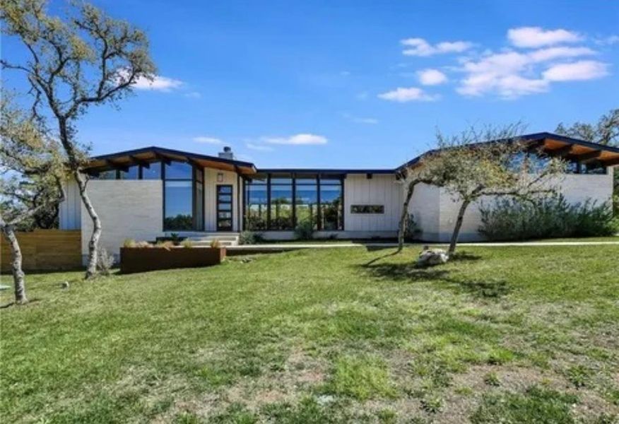 Back of house with a lawn, board and batten siding, and a patio area Back of house with a lawn, board and batten siding, and a patio area