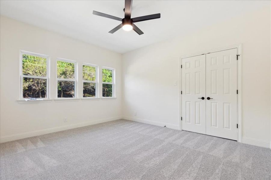 Carpeted empty room with ceiling fan