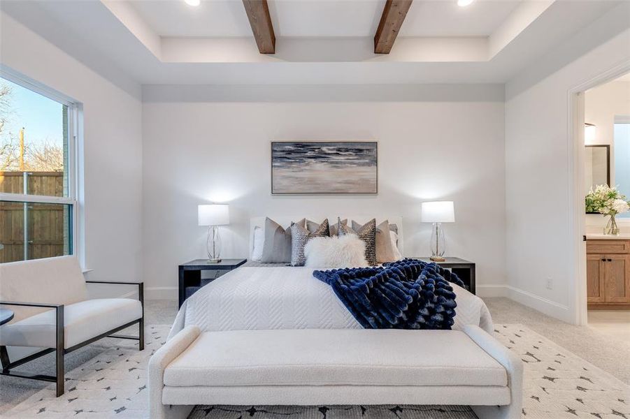 Luxe primary bedroom with coffered ceiling, light carpet, and beamed ceiling. Luxe primary bedroom with coffered ceiling, light carpet, and beamed ceiling.