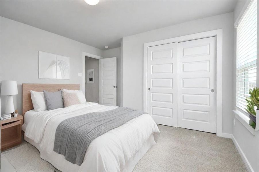 Secondary bedrooms showcase 5-panel doors adorned with modern hardware, large windows enhanced by privacy blinds, and spacious closets featuring sleek and contemporary finishes. Sample photo of completed home with similar floor plan. As-built interior colors and selections may vary.