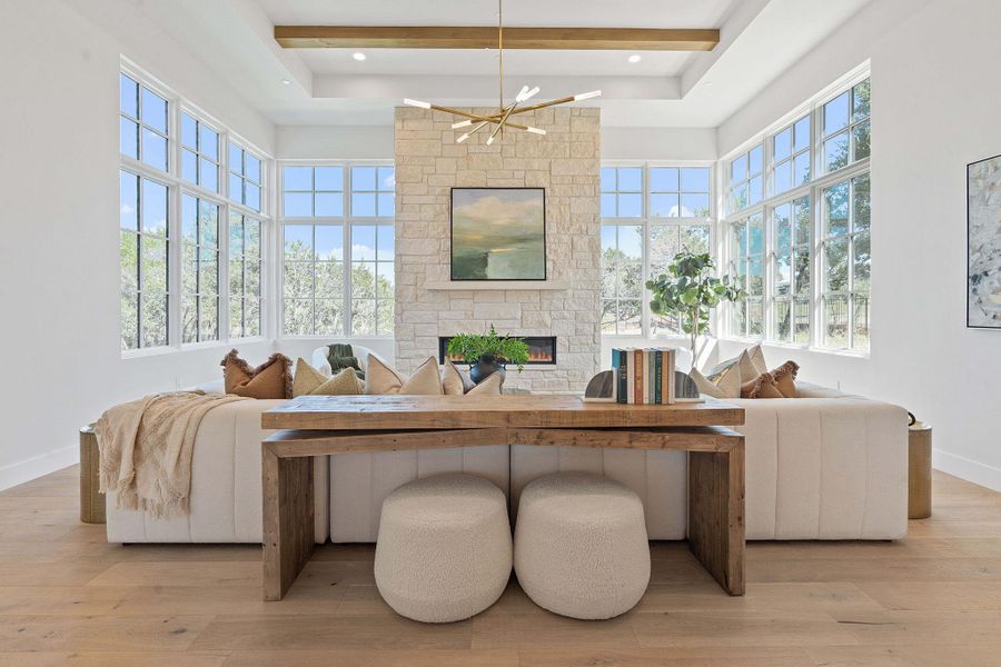 Living area with a high ceiling, beamed ceiling, light wood-style flooring, and a notable chandelier Living area with a high ceiling, beamed ceiling, light wood-style flooring, and a notable chandelier
