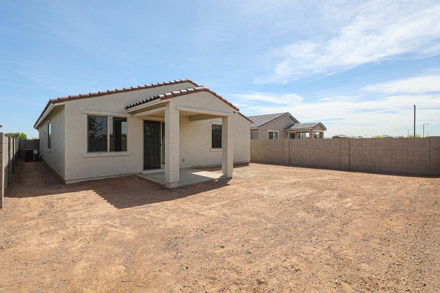 A house in a dirt yard.