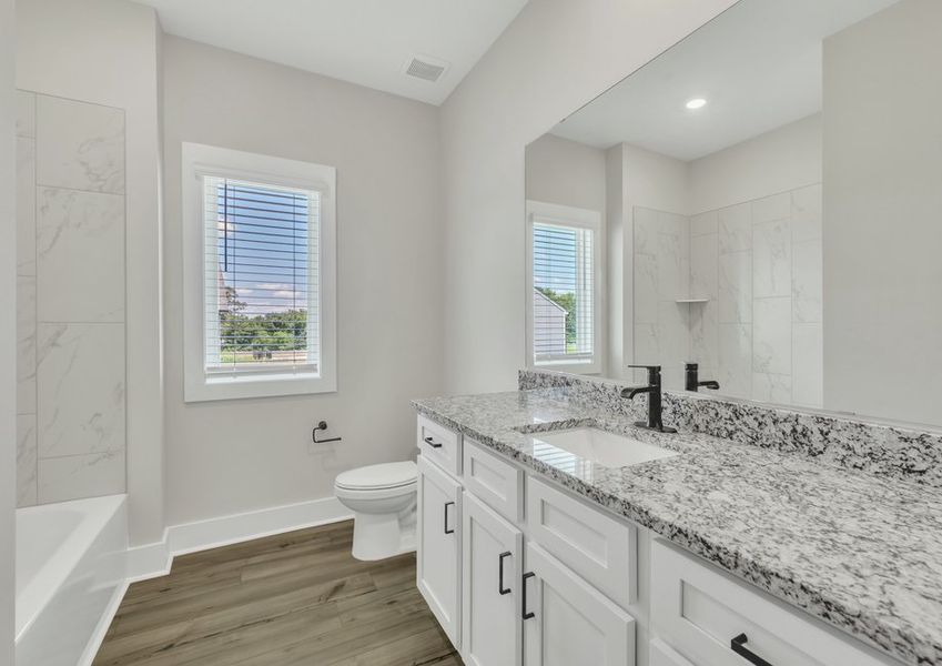 The secondary bathroom comes with a large soaking tub.