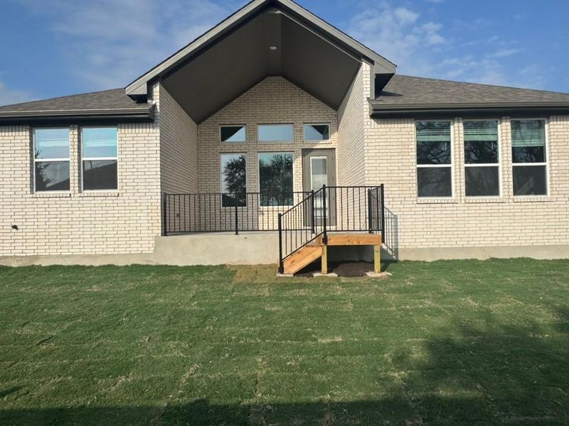 Rear view of house with brick siding and a yard Rear view of house with brick siding and a yard