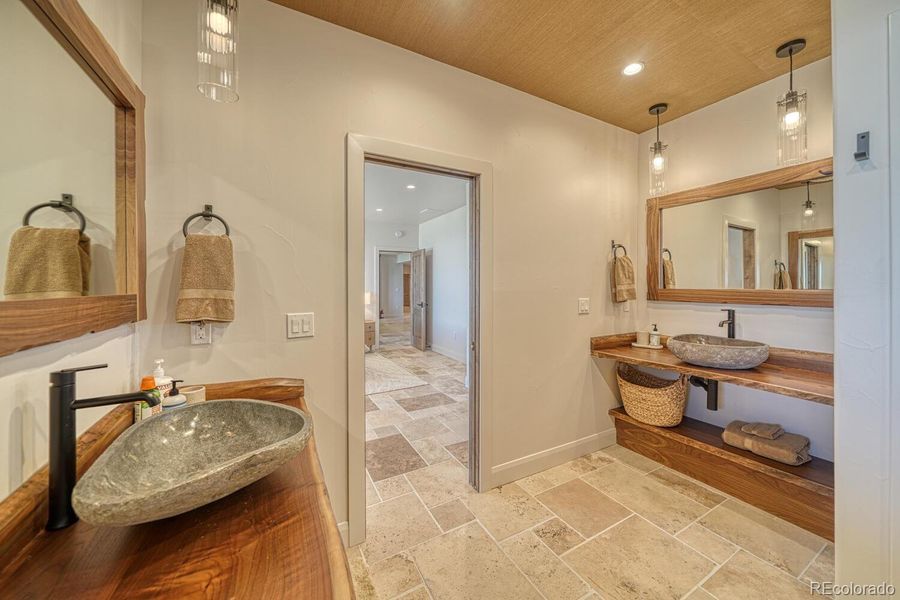 A spa-quality bath with dual black walnut vanities, a large walk-in shower, and a private water closet. A spa-quality bath with dual black walnut vanities, a large walk-in shower, and a private water closet.