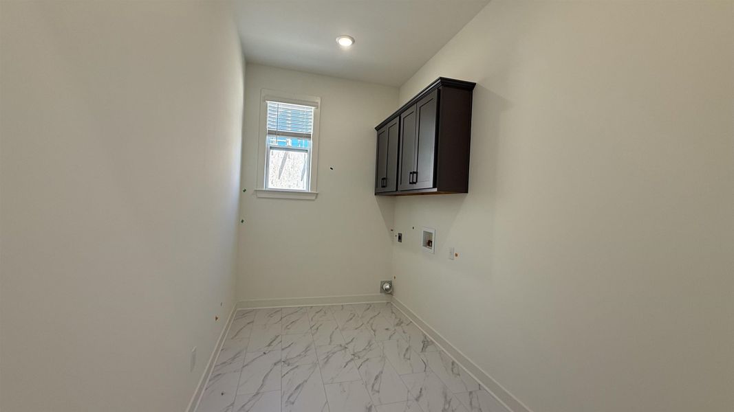 Laundry area featuring cabinet space, gas dryer hookup, light marble finish flooring, washer hookup, and hookup for an electric dryer