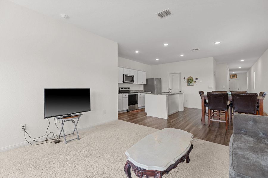 Living area with recessed lighting, light colored carpet, and light wood-type flooring Living area with recessed lighting, light colored carpet, and light wood-type flooring