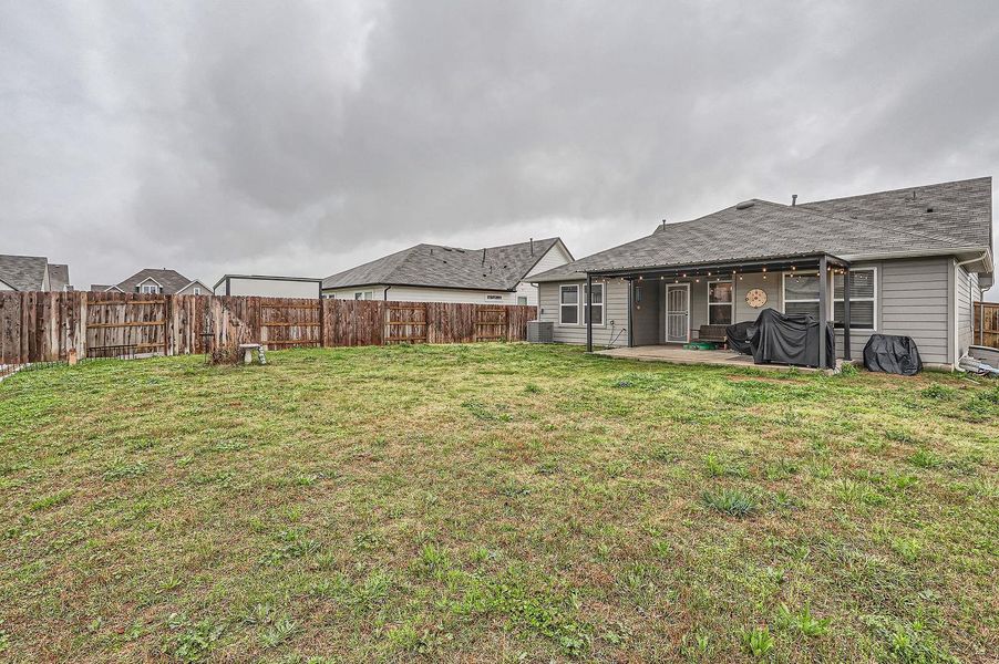 View of yard featuring a patio, a fenced backyard, and central AC