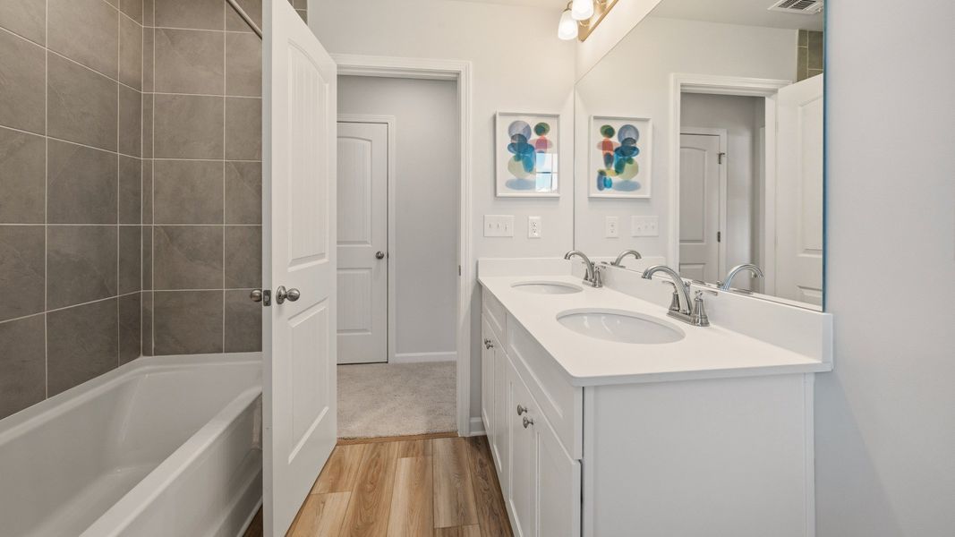 Secondary bathroom with dual vanity and tiled shower Secondary bathroom with dual vanity and tiled shower