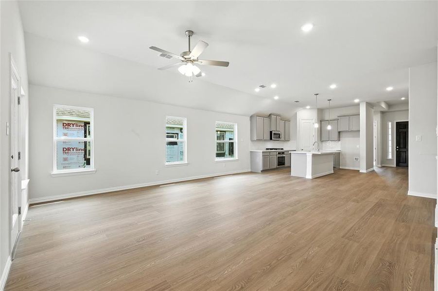 Unfurnished living room featuring recessed lighting, ceiling fan, light wood finished floors, and vaulted ceiling