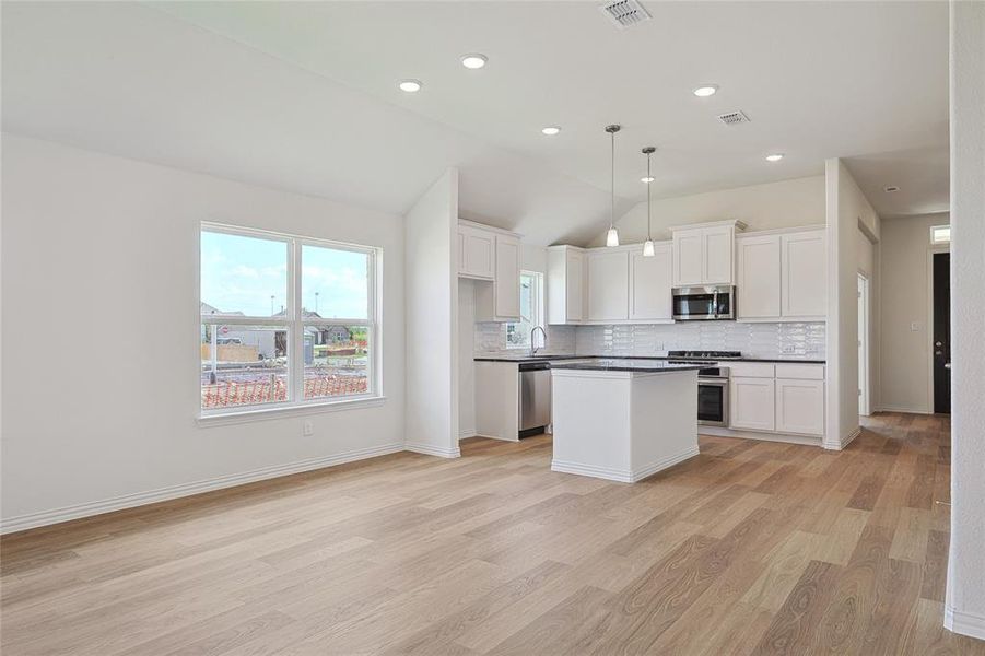 Kitchen featuring white cabinetry, stainless steel appliances, and light hardwood / wood-style floors