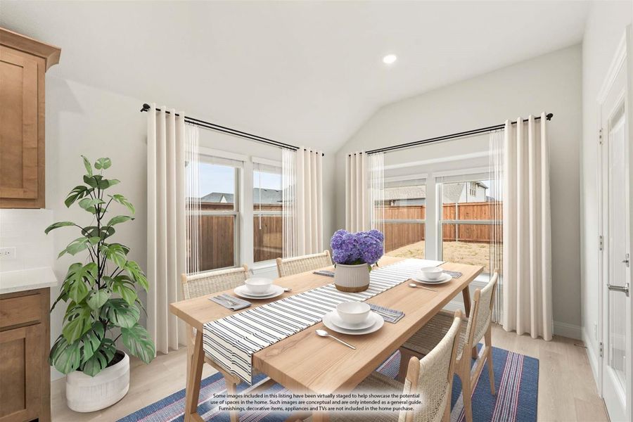 Dining area with wood table, woven chairs, vaulted ceiling, and large windows with backyard view Dining area with wood table, woven chairs, vaulted ceiling, and large windows with backyard view