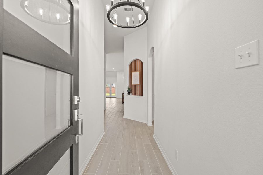 The entry way is bright, open, and features the wood tille flooring that extends throughout the main living areas, making it easy to clean and maintain! It's finished with modern light fixture and decorative art niche giving it a warm and custom feel