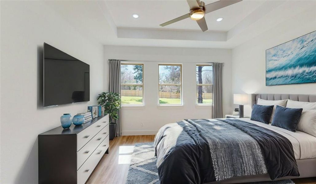 Bedroom featuring light wood-style floors, recessed lighting, a raised ceiling, and baseboards