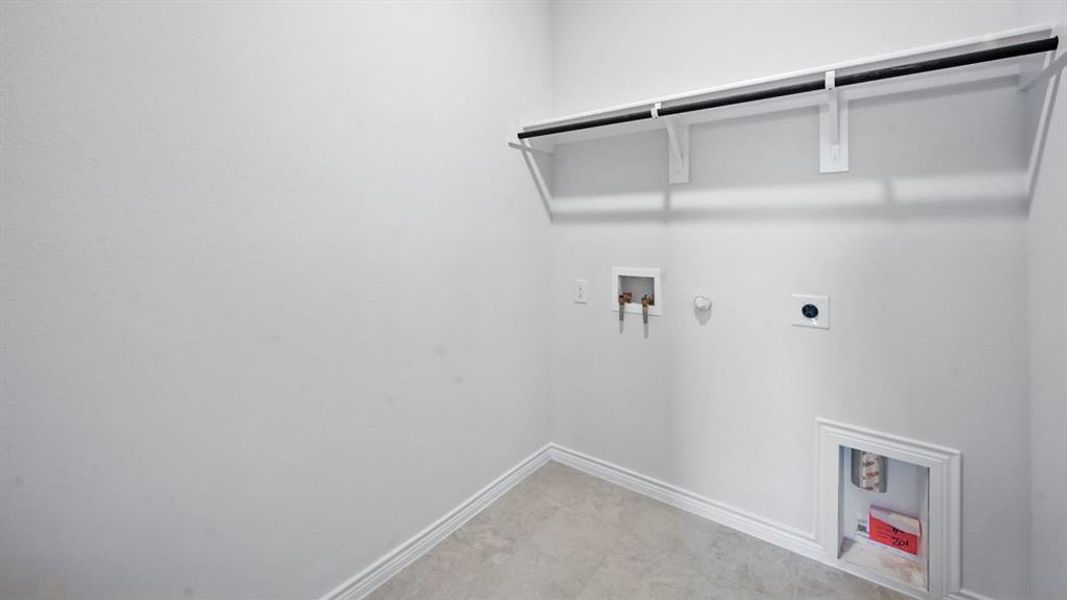 Dedicated laundry area featuring a wall-mounted shelving unit with a hanging rod Dedicated laundry area featuring a wall-mounted shelving unit with a hanging rod