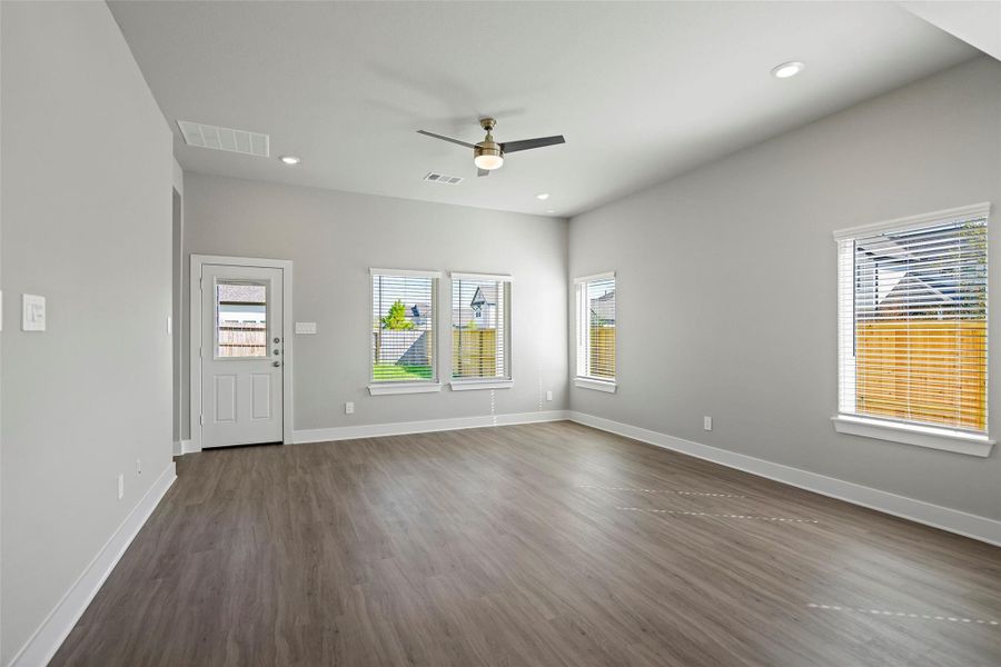 Sunny living area positioned off the kitchen, framed by windows overlooking the backyard.