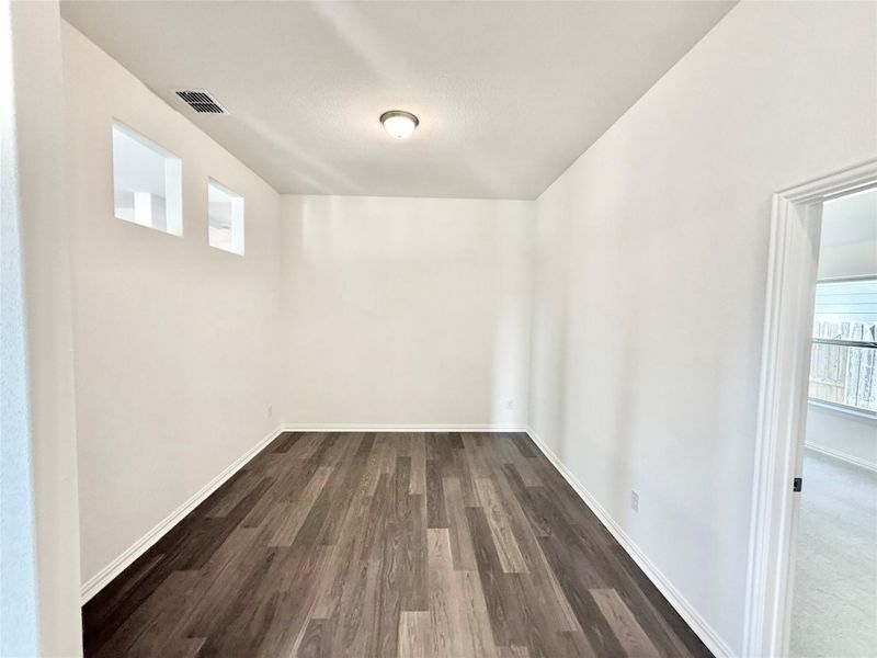 Unfurnished room featuring dark wood-style flooring and baseboards