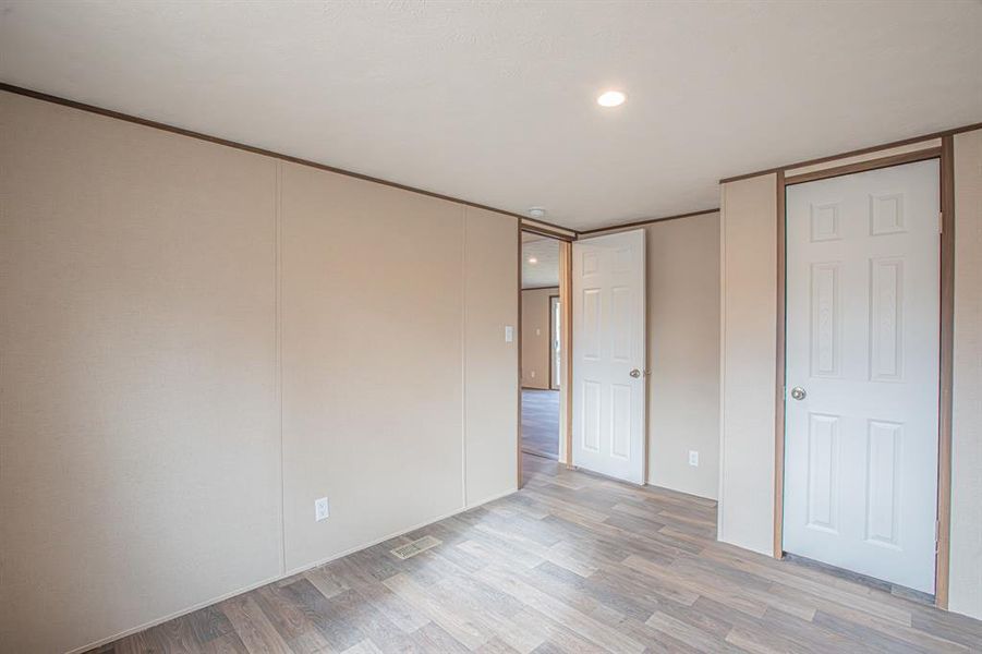 Unfurnished bedroom featuring wood finished floors, recessed lighting, and a closet Unfurnished bedroom featuring wood finished floors, recessed lighting, and a closet