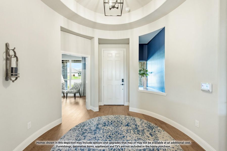 Round foyer with tray ceiling, pendant light, white front door, and hardwood floors Round foyer with tray ceiling, pendant light, white front door, and hardwood floors