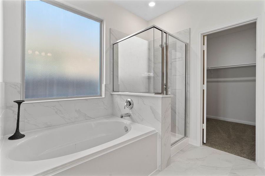 This additional view of the primary bath showcases a walk-in shower with tile surround and a separate garden tub perfect for soaking after a long day.