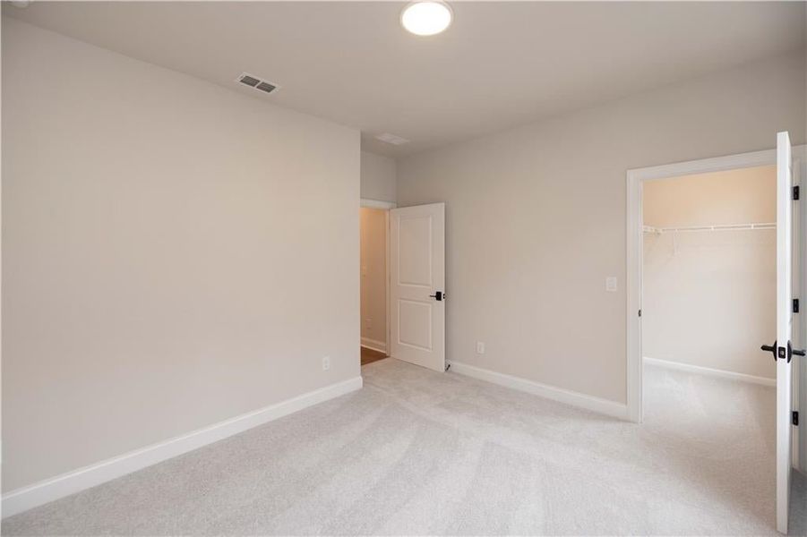 Unfurnished bedroom with a spacious closet and carpet floors