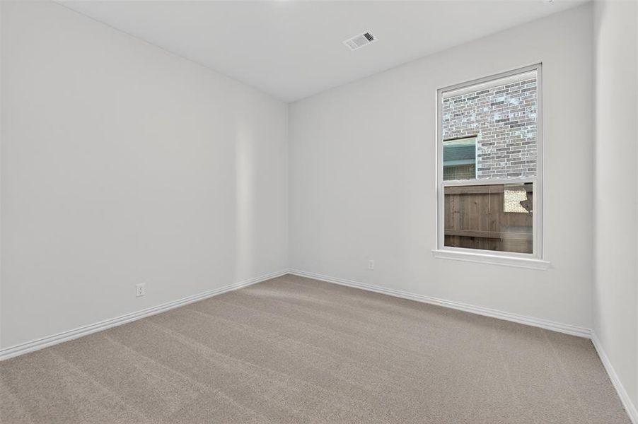 Empty room featuring light carpet and baseboards