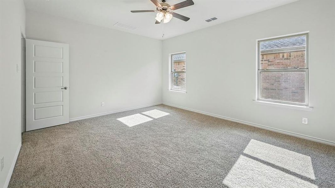 Spacious room featuring neutral carpeting, light-toned walls, and a ceiling fan Spacious room featuring neutral carpeting, light-toned walls, and a ceiling fan