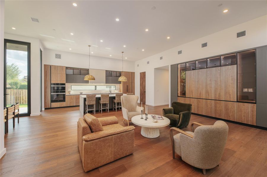 A spacious, luminous living area with open floorplan seamlessly transitions into a well-appointed kitchen.