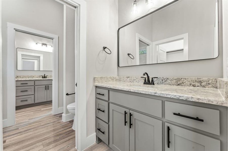 Bathroom featuring toilet, vanity, and hardwood / wood-style flooring