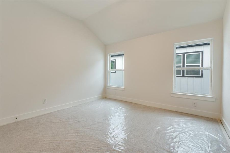 Empty room with lofted ceiling