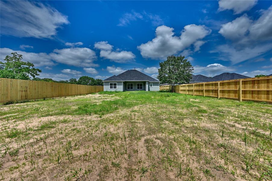Spacious fenced yard with privacy fence.