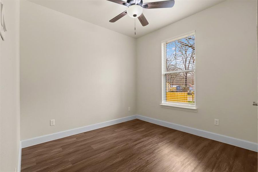 Empty room with dark hardwood / wood-style floors and ceiling fan