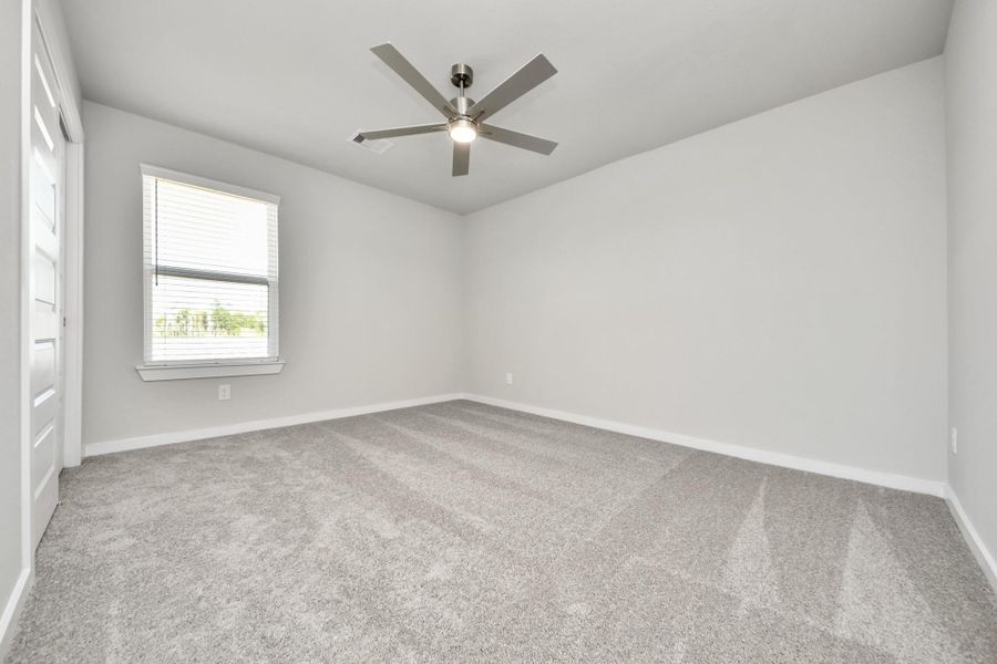 Secondary bedroom features plush carpeting, large windows that let in plenty of natural light, bright paint, and spacious closets.