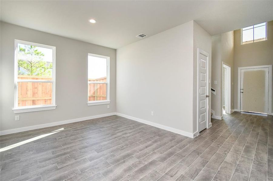 An inviting dining space adjacent to the kitchen for added convenience. Revel in the stunning floors, soothing paint palette, and the large windows with privacy blinds – a perfect setting for shared meals and cherished moments. Sample photo of completed home with similar floor plan. Actual colors and selections may vary.