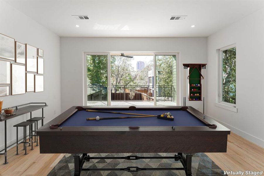 Recreation room with light hardwood / wood-style floors and billiards