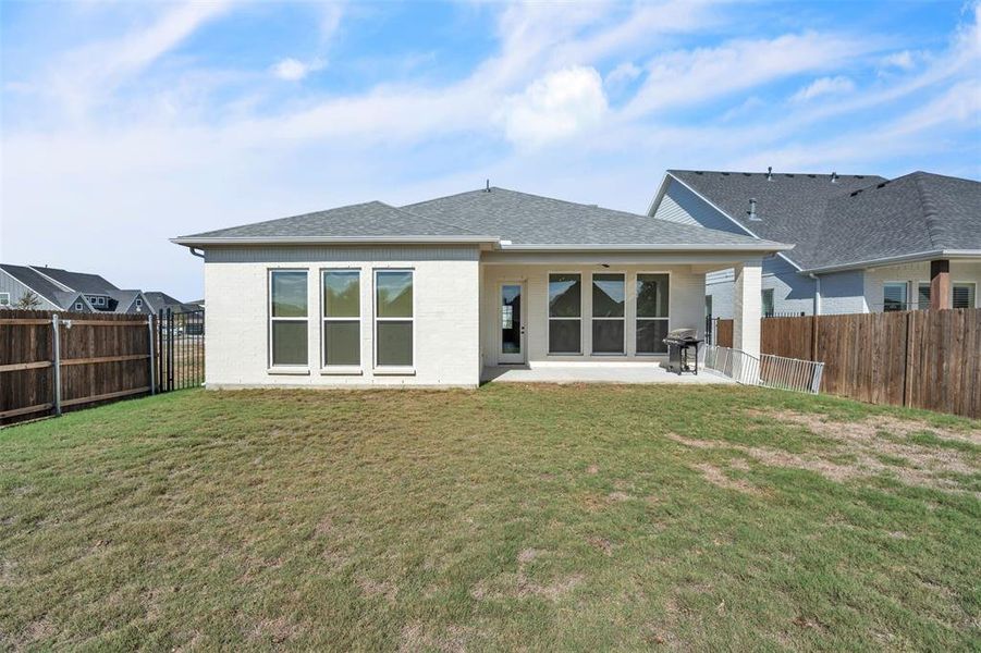 Back of house featuring a yard and a patio area