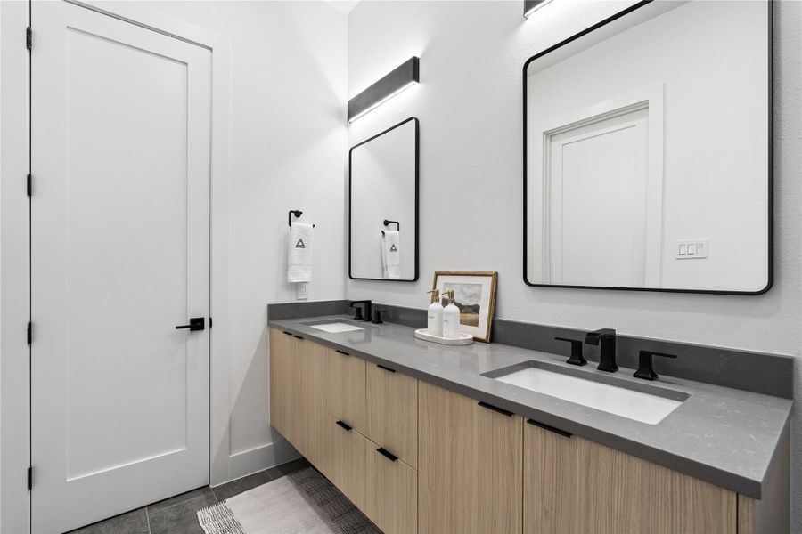 A spa-caliber composition: a floating oak vanity stretches beneath sculptural mirrors, while a freestanding soaking tub rests beside a zero-threshold, frameless shower wrapped in large-format, parquet-pattern tile.Subtle LED wash lighting and matte-black fittings sharpen the silhouette—an elevated suite for unhurried rituals and end-of-day exhale.